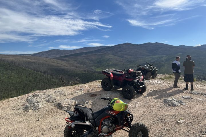 a motorcycle parked on the side of a dirt road
